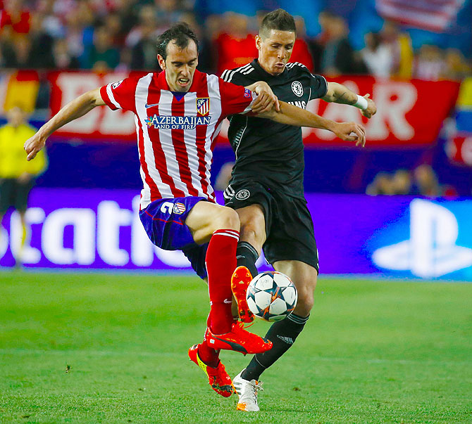 Atletico Madrid's Diego Godin (left) challenges Chelsea's Fernando Torres (right) during their Champions League semi-final first leg match at Vicente Calderon stadium in Madrid on Tuesday
