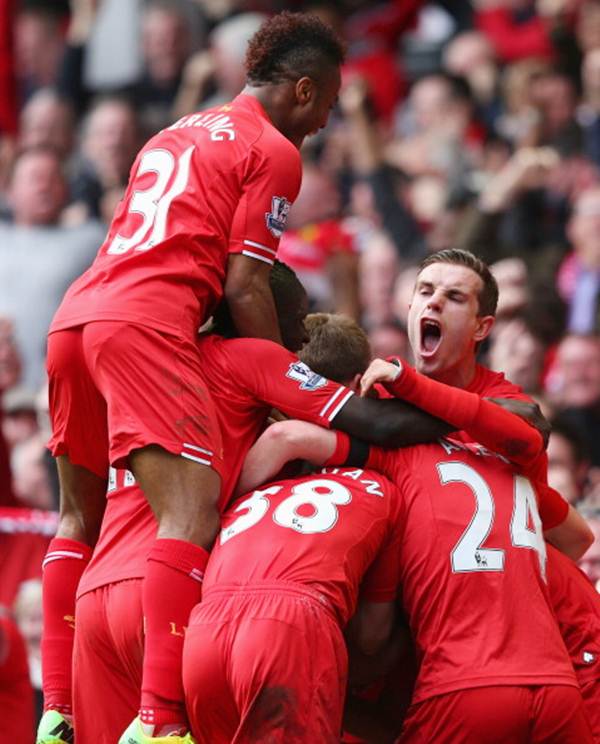 Philippe Coutinho of Liverpool is mobbed by team-mates after scoring the third goal during the Barclays Premier League match against Manchester City at Anfield on April 13.