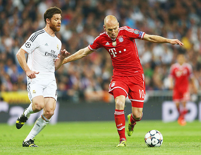 Arjen Robben of Bayern Munich is challenged by Xabi Alonso of Real Madrid during the UEFA Champions League semi-final first leg match on Wednesday