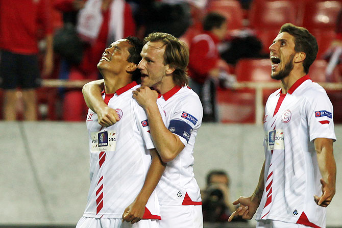 Sevilla's Carlos Bacca (left) celebrates with teammates Ivan Rakitic (centre) and Daniel Carrico after scoring against Valencia during their Europa League semi-final first leg match at Ramon Sanchez Pizjuan stadium in Seville on Thursday