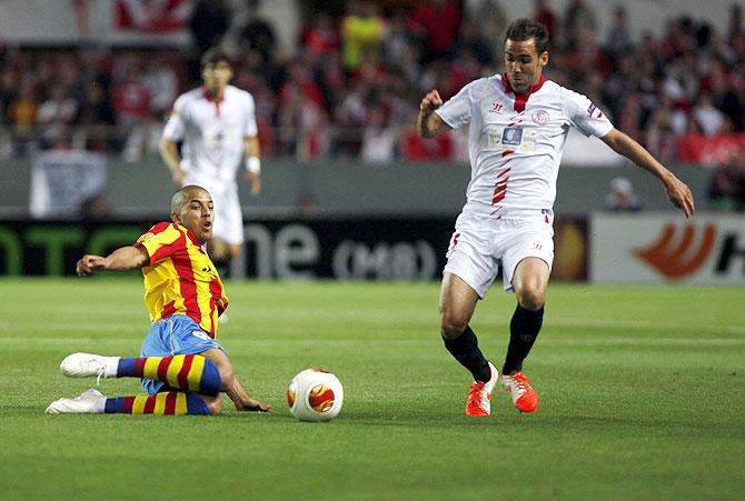 Valencia's Sofiane Feghouli (left) and Sevilla's Fernando Navarro fight for the ball during their Europa League semi-final first leg match at Ramon Sanchez Pizjuan stadium in Seville on Thursday