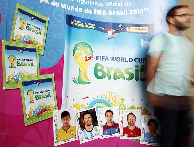 A man walks past the banner of the official 2014 FIFA World Cup sticker album in Sao Paulo