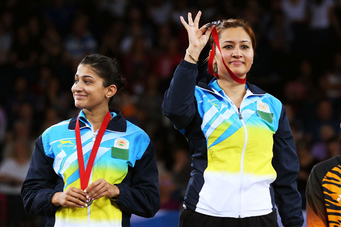 Silver medalists Ashwini Ponnappa and Jwala Gutta of India pose in the medal ceremony