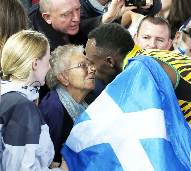 Jamaica's Usain Bolt kisses a woman in the stands after Jamaica won the men's 4x100m relay final at the 2014 Commonwealth Games in Glasgow