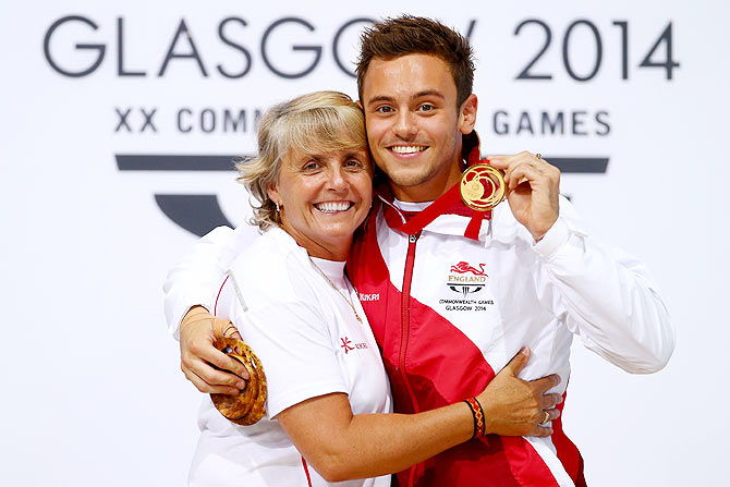 Tom Daley of England celebrates on the podium with his coach Jane Figueiredo after   winning the Gold medal in the Men's 10m Platform Final at the Royal Commonwealth Pool
