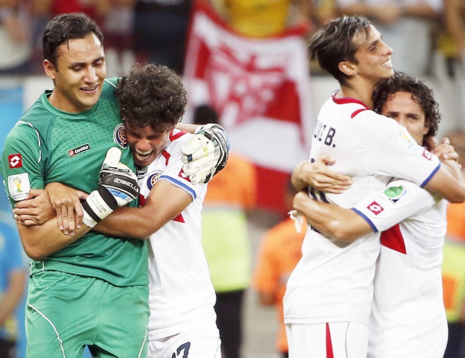 Costa Rica midfielder Yeltsin Tejeda (17) hugs Costa Rica goalkeeper Keylor Navas
