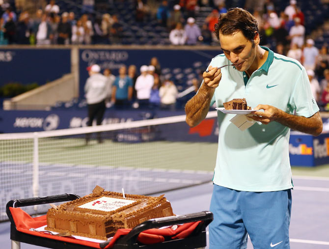 Roger Federer of Switzerland has a piece of his birthday cake after his quarter-finals win against David Ferrer of Spain during the Rogers Cup at Rexall Centre at York University in Toronto on Friday