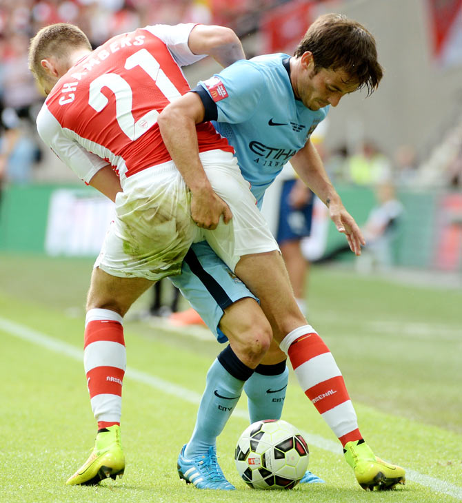 Calum Chambers of Arsenal grapples with David Silva of Manchester City as they fight for possession during their FA Community Shield match at Wembley Stadium in London on Sunday