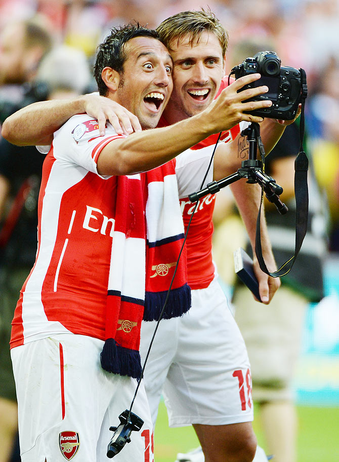 Santi Cazorla of Arsenal and team-mate Nacho Monreal (right) celebrate by clicking a selfie after winning the FA Community Shield final against Manchester City on Sunday