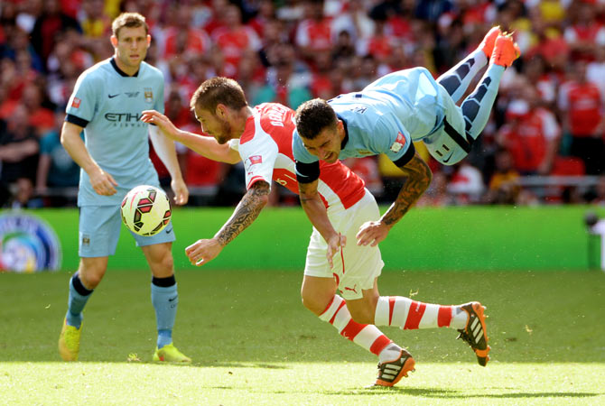 Aleksandar Kolarov of Manchester City is challenged by Mathieu Debuchy of Arsenal during their FA Community Shield match on Sunday