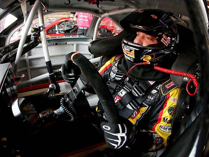 Tony Stewart, driver of the #14 Rush Truck Centers/Mobil 1 Chevrolet, sits in his car in the garage area during practice for the NASCAR Sprint Cup Series Cheez-It 355 at Watkins Glen International on Friday