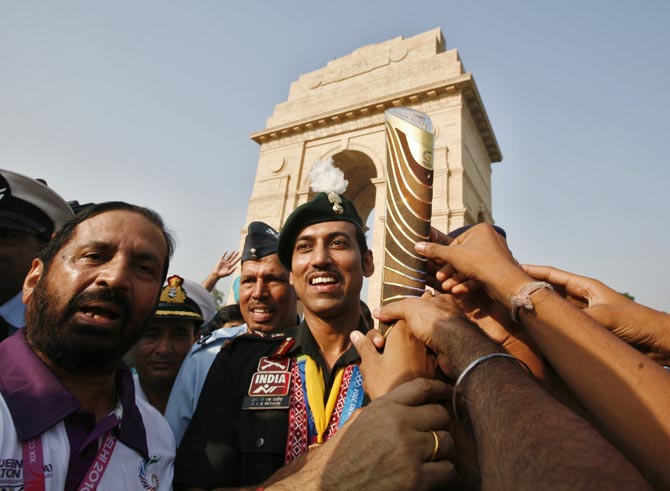 Rajyavardhan Singh Rathore (centre) with the baton during the Commonwealth Games Queen's Baton Relay in New Delhi on October 1, 2010.