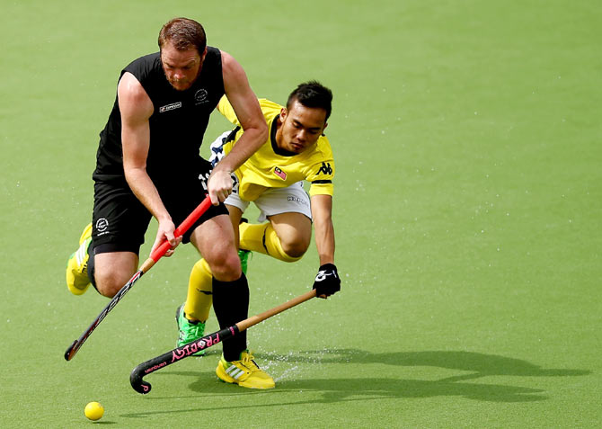 Bradley Shaw of New Zealand is challenged by Meor Hasan of Malaysia (right)