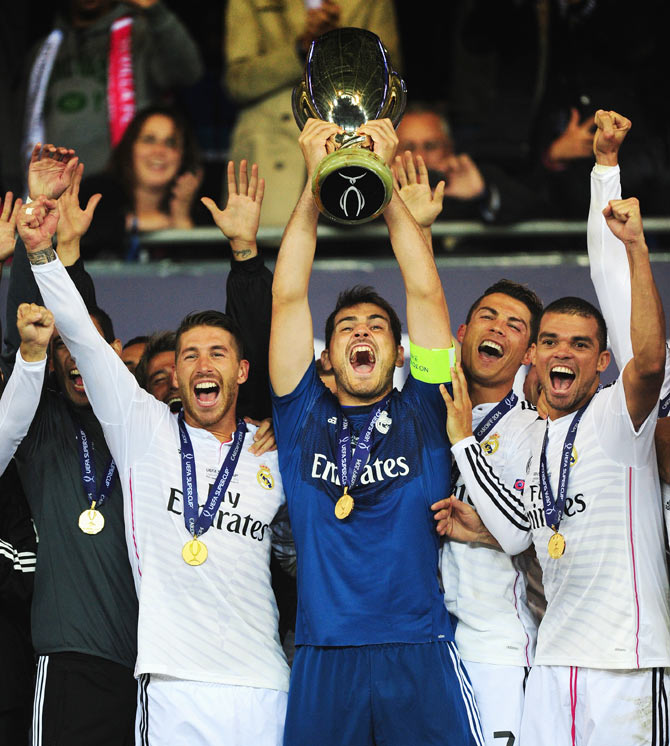 Real Madrid players (left to right) Sergio Ramos, Iker Casillas, Ronaldo and Pepe (right) celebrate with the trophy after the UEFA Super Cup match between Real Madrid and Sevilla FC at Cardiff City Stadium on Tuesday