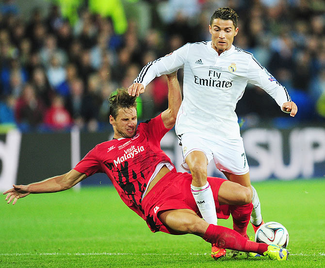 Real Madrid player Ronaldo (right) is challenged by Grzegorz Krychowiak of Sevilla during their UEFA Super Cup match at Cardiff City Stadium on Tuesday