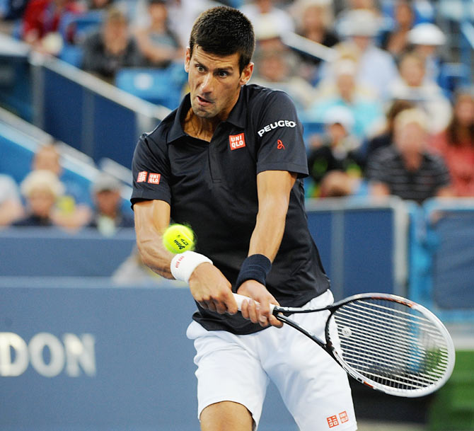 Novak Djokovic of Serbia returns to Gilles Simon of France during a match on day 4 of the Western & Southern Open in Cincinnati on Tuesday