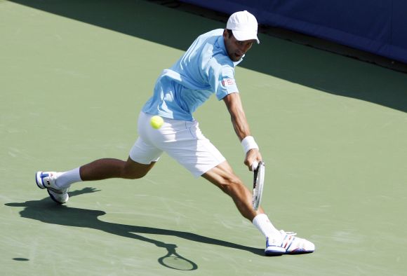 Novak Djokovic returns the shot from Tommy Robredo on day four of the Western and Southern Open 