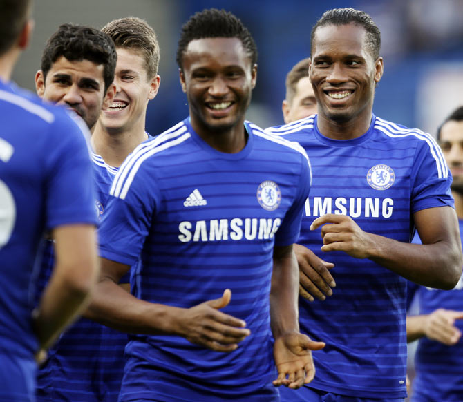 Chelsea's Didier Drogba (right) runs with his teammates during a warm-up session