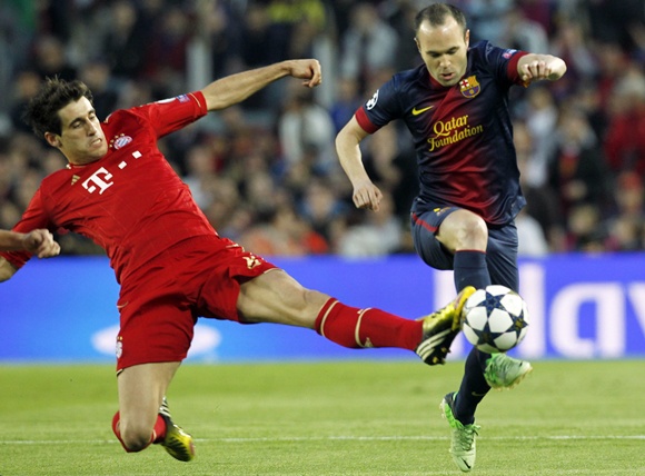 Bayern Munich's Javi Martinez tackles Barcelona's Andres Iniesta