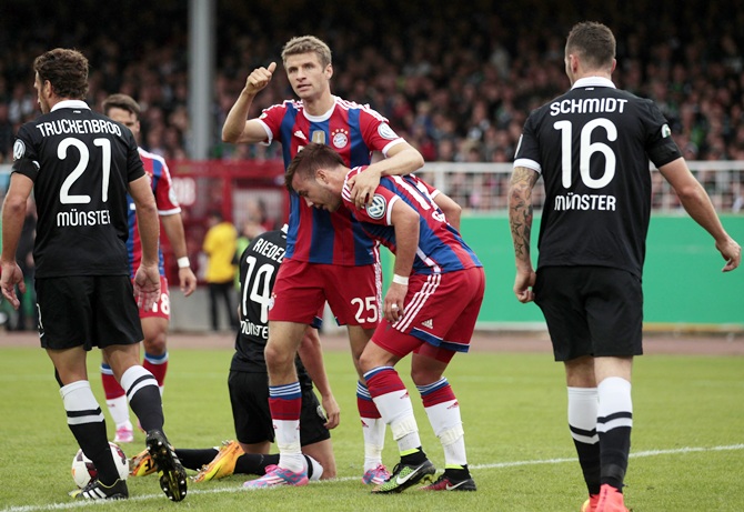 Bayern Munich's Thomas Mueller and teammate Mario Goetze, second right, celebrate a goal against Preussen Muenster