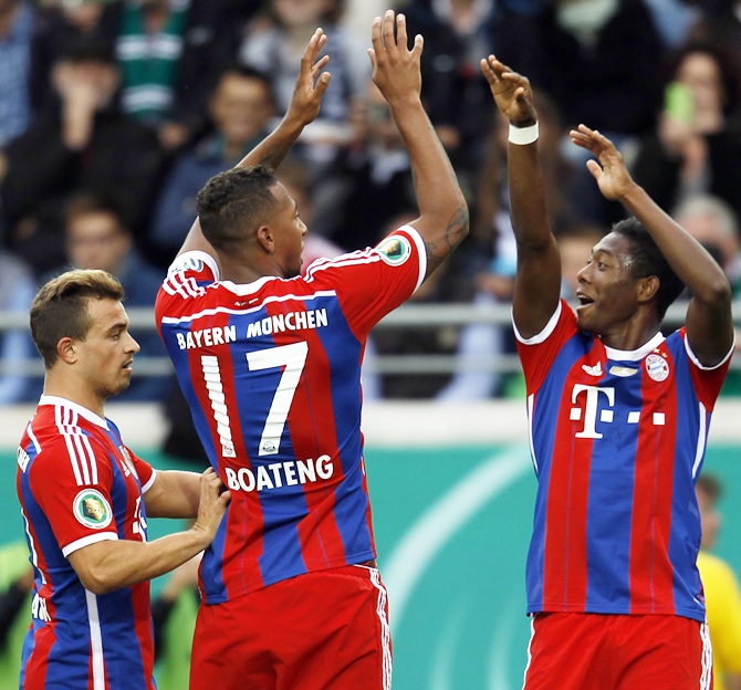 Bayern Munich's Jerome Boateng, centre, and David Alaba, right, celebrate a goal against Preussen Muenster