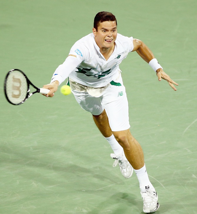 Milos Raonic of Canada hits a return during his match against Roger Federer