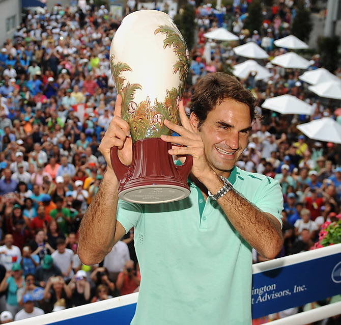 Roger Federer of Switzerland poses with the winner's trophy on the Champion's Balcony after beating David Ferrer of Spain to win the Cincinnati title on Sunday