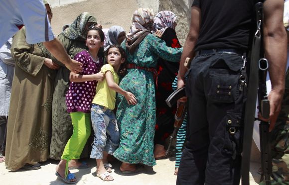 Girls queue to buy bread at the only bakery serving the outskirts of Idlib province