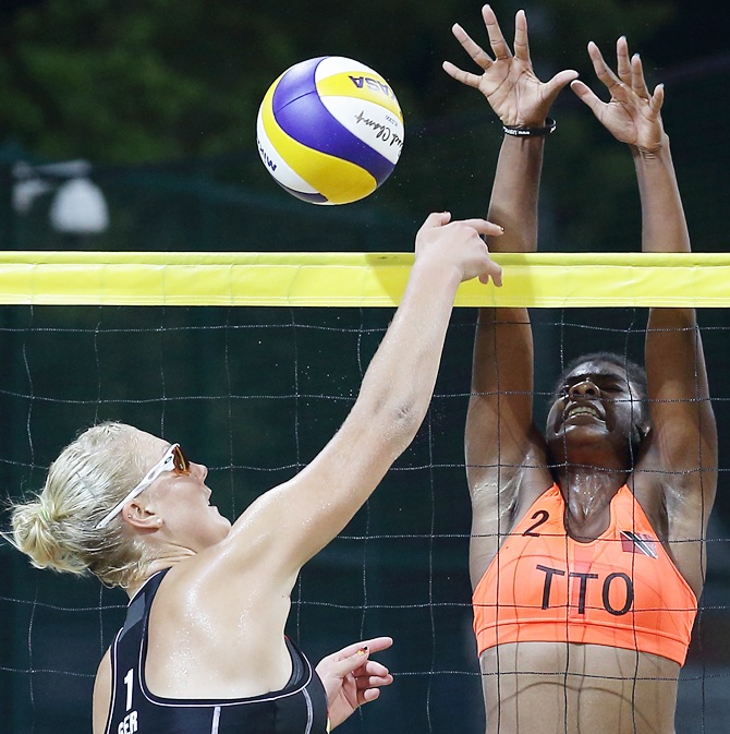Malika Davidson of Trinidad and Tobago attempts to block Sarah Schneider of Germany shot during the Nanjing 2014 Youth Olympic Beach Volleyball