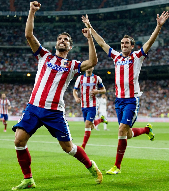Raul Garcia, left, of Atletico de Madrid celebrates scoring their opening goal with teammate Diego Godin during the Supercopa first leg match between Real Madrid and Club Atletico de Madrid at Estadio Santiago Bernabeu