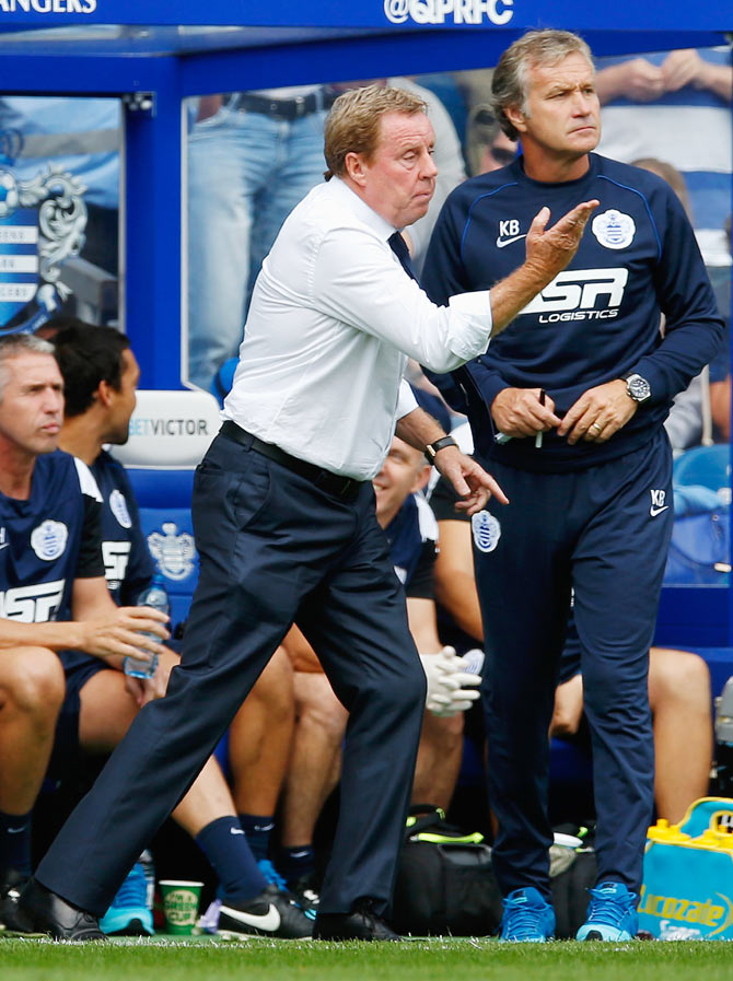 Harry Redknapp manager of Queens Park Rangers directs his side as Kevin Bond (r) looks on 