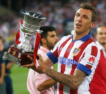 Atletico Madrid's Mario Mandzukic celebrates with the trophy after they won the Spanish Super Cup against Real Madrid at the Vicente Calderon stadium in Madrid 