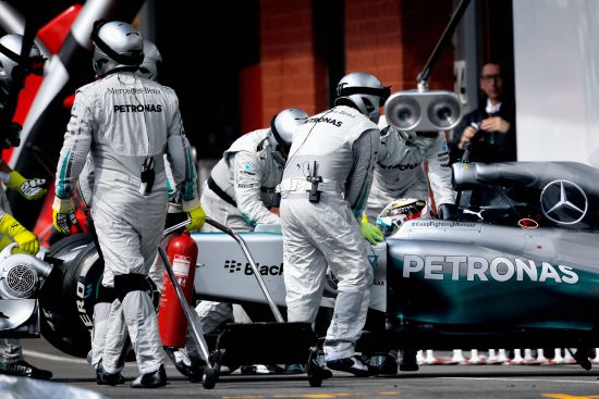 Lewis Hamilton of Great Britain and Mercedes GP is pushed back into the garage after retiring during the Belgian Grand Prix 