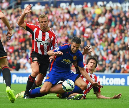 Robin van Persie of Manchester United is tackled by Lee Cattermole (L) and Santiago Vergini of Sunderland during the Barclays Premier League match 