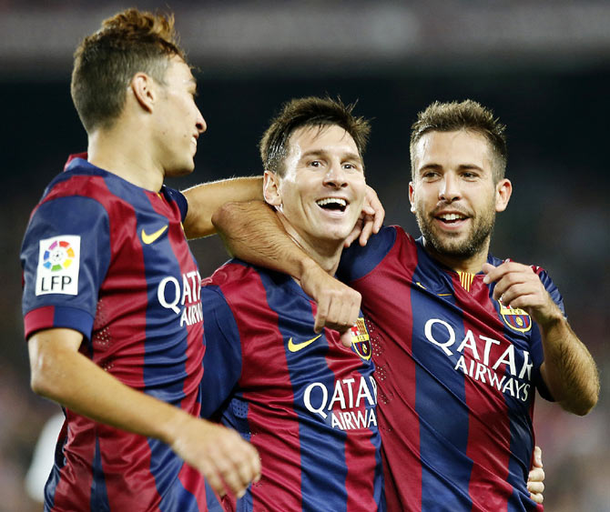 Barcelona's Lionel Messi (centre) celebrates his second goal with teammate Munir El Haddadi (left) and Jordi Alba during their Spanish first division La Liga match against Elche at Nou Camp stadium in Barcelona on Sunday