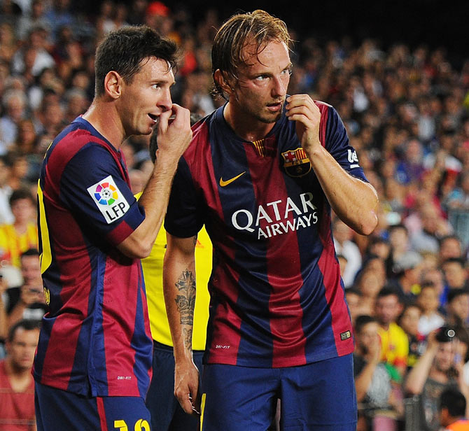 Barcelona's Ivan Rakitic (right) consults with teammate Lionel Messi before taking a freekick during the La Liga match on Sunday