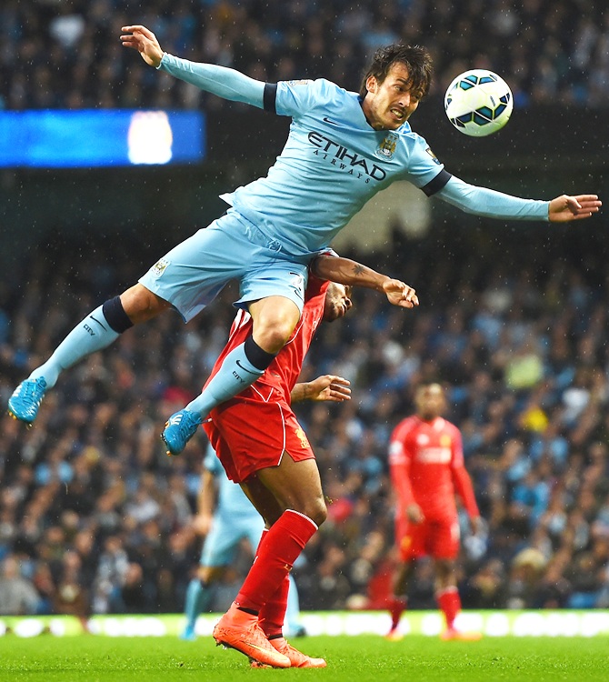 Raheem Sterling of Liverpool tangles with David Silva of Manchester City