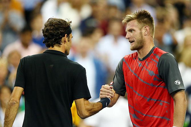 Roger Federer of Switzerland shakes hands with Sam Groth of Australia 