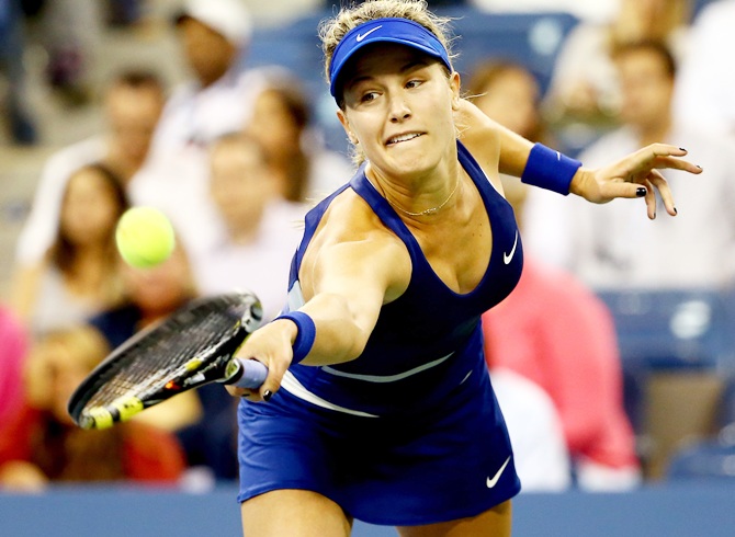 Eugenie Bouchard of Canada returns a shot against Sorana Cirstea of Romania