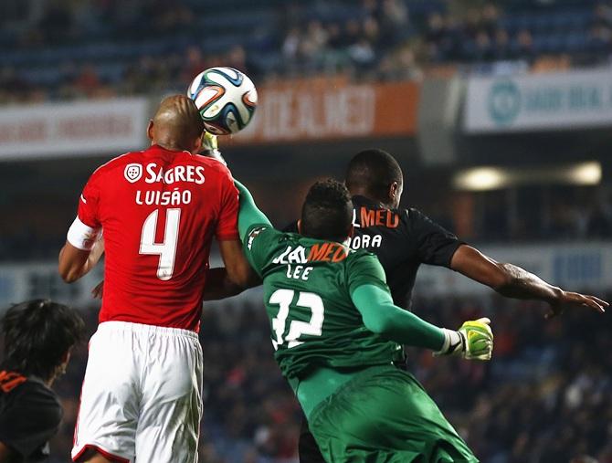 Benfica's Luisao, left, heads the ball to score his goal near Academica's goalkeeper Lee Oliveira during their Portuguese Premier League soccer match at the Coimbra city stadium