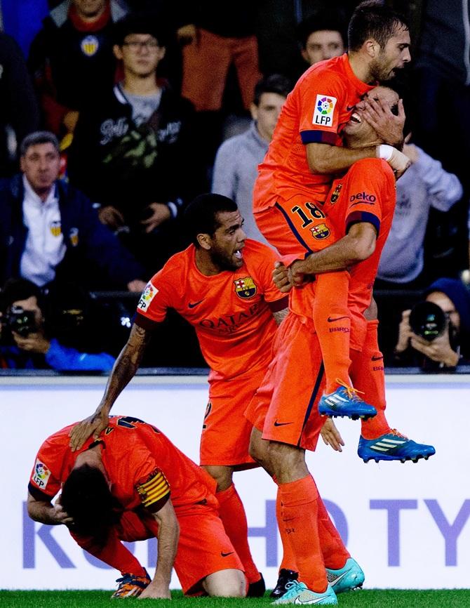 Sergio Busquets Burgos, right, of FC Barcelona celebrates scoring their opening goal with team mate Jordi Alba, Dani Alves and Lionel Messi, left, during the La Liga match 