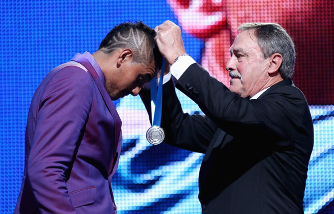 Australian tennis player Nick Kyrgios is presented with the Newcombe Medal by John Newcombe at the 2014 Newcombe Medal Awards at Crown Palladium in Melbourne on November 24