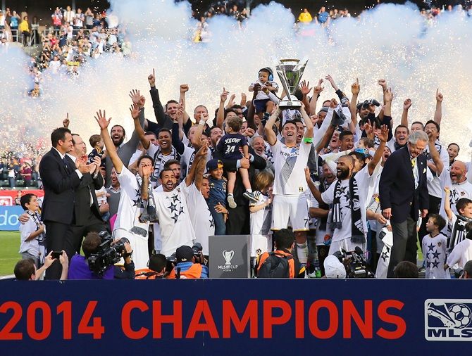 Captain Robbie Keane of the Los Angeles Galaxy hoists up the Philip F Anschutz Trophy on   the podium as his Galaxy teammates cheer on 