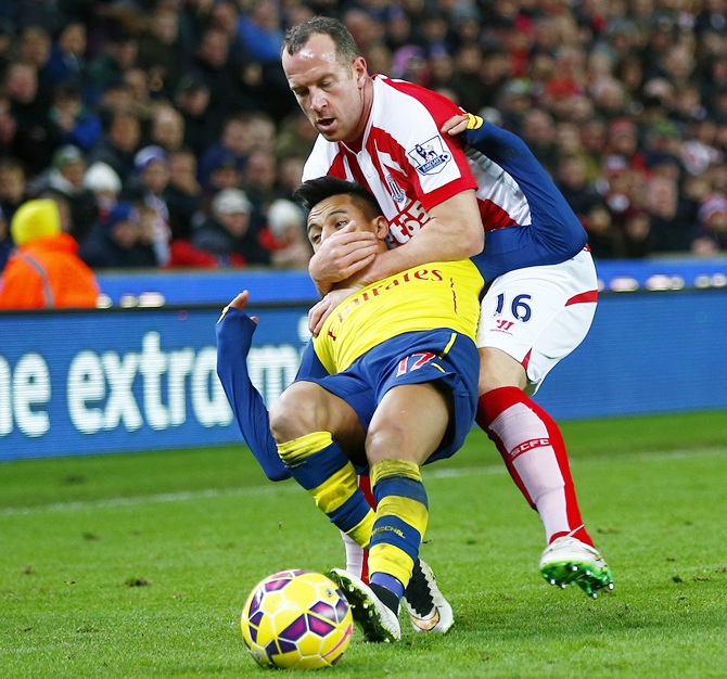 Stoke City's Charlie Adam (top) gets a yellow card for this foul on Arsenal's Alexis Sanchez