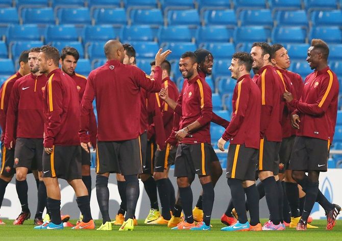 AS Roma players share a joke during a training session