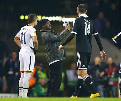 Image: A pitch invader tries to take a 'selfie' with Erik Lamela of Tottenham Hotspur during the UEFA Europa League Group C match between Spurs and FK Partizan at White Hart Lane in London