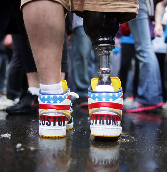 The shoes of 2013 Boston Marathon bombing survivor J.P. Norden read 'Boston Strong' as he stands at the finish line on the one-year anniversary of the bombings in Boston, Massachusetts on April 15