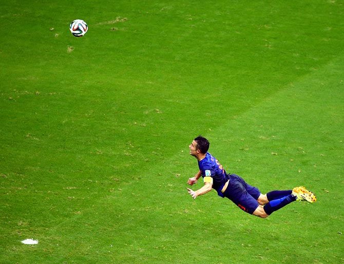Robin van Persie of the Netherlands scores the team's first goal with a diving header against Spain in their 2014 FIFA World Cup opener in Salvador