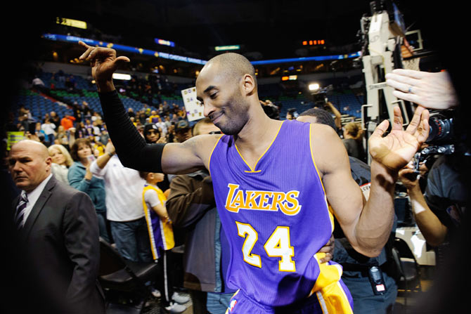 Kobe Bryant #24 of the Los Angeles Lakers is greeted by fans as he leaves the court after the game against the Minnesota Timberwolves on Sunday