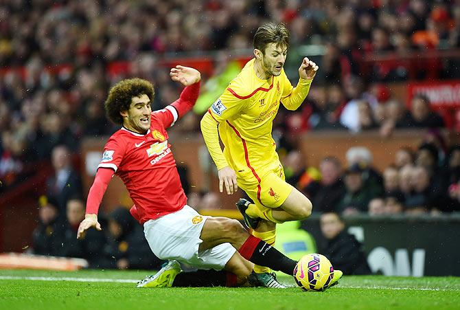 Marouane Fellaini of Manchester United challenges Adam Lallana of Liverpool